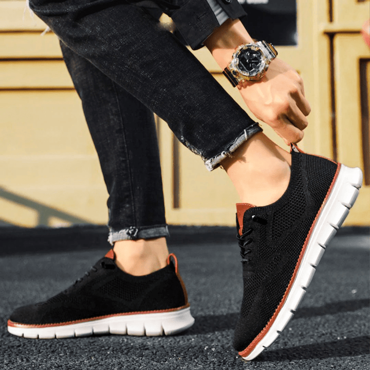 Vue latérale de baskets noir avec maille légère, lacets assortis et semelle de marche confortable