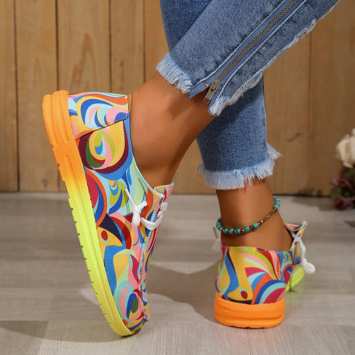 Chaussures de sport femme à imprimé multicolore portées en mouvement, mettant en valeur la semelle jaune et le design artistique