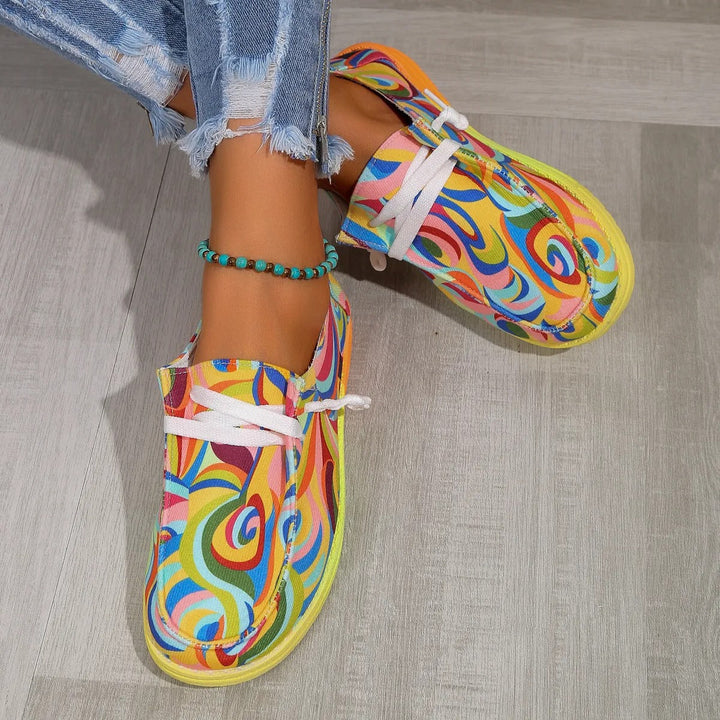 Vue rapprochée de baskets multicolores jaune pour femme avec lacets blancs, motifs tourbillonnants et semelle épaisse confortable